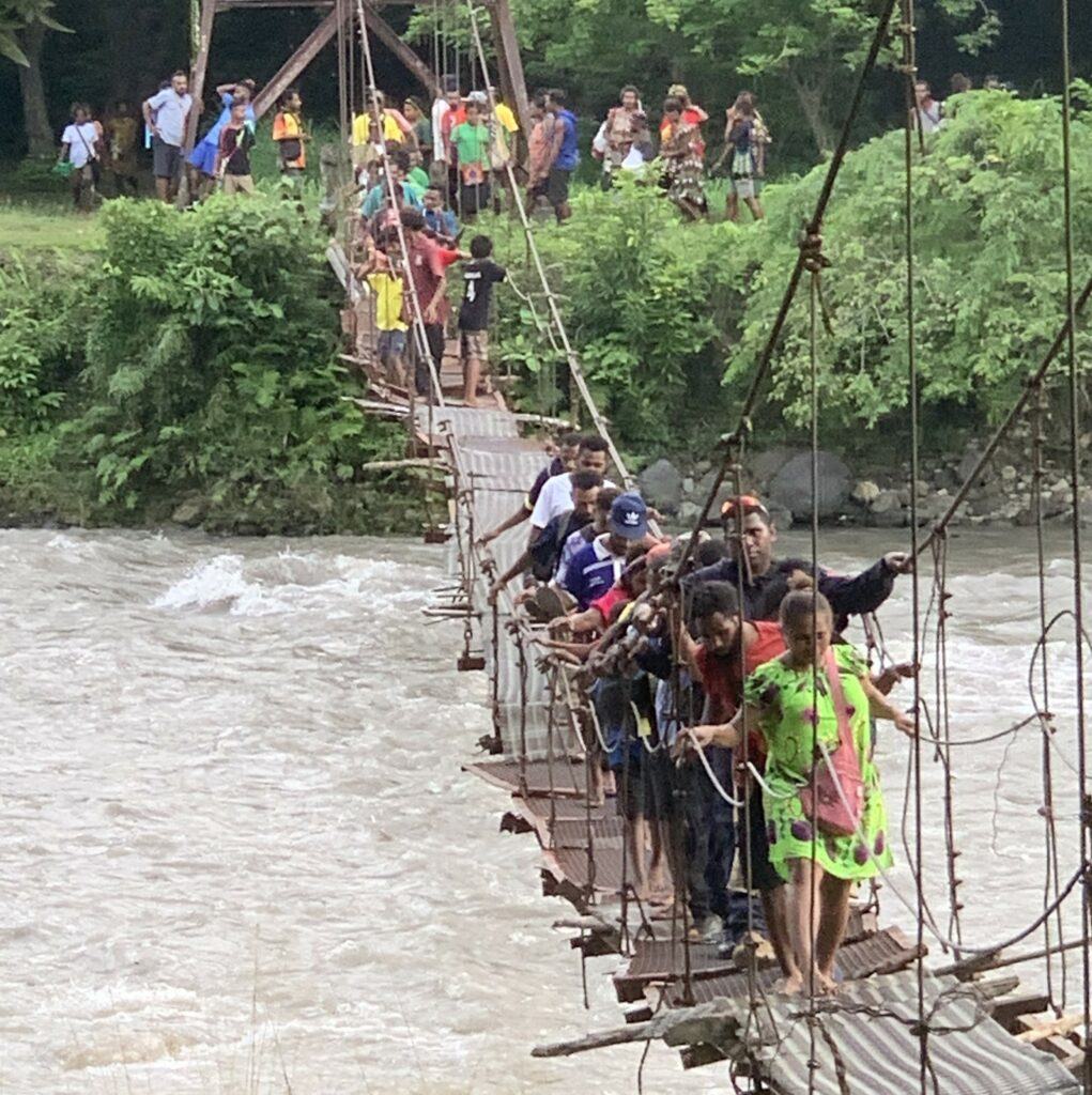 People of Yaganon crossing the Gawar River foot bridge